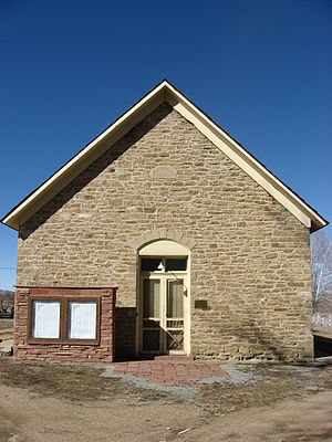 A photograph of the front of a stone and redbrick church.
