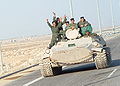 Iraqi military men riding on tank.jpg