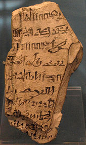 Светлый фрагмент камня с иератической почерком черными чернилами на поверхности